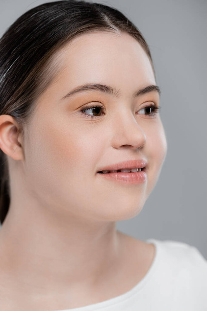 Smiling woman with down syndrome looking away isolated on grey  - Photo, Image