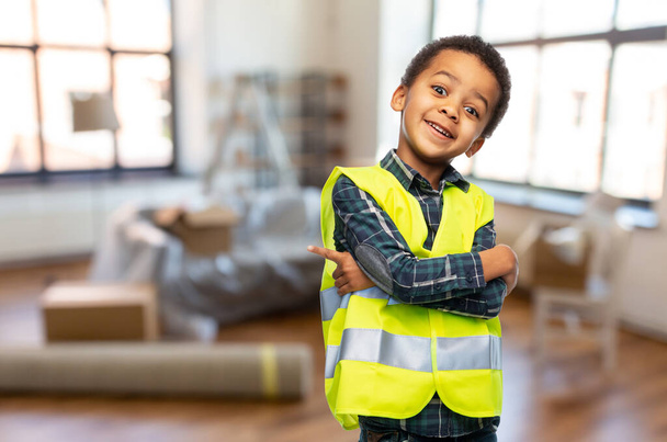 boy in safety vest with crossed arms at home - Photo, image