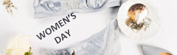 Top view of accessories near lingerie and card with womens day lettering on white background, banner  - Photo, Image