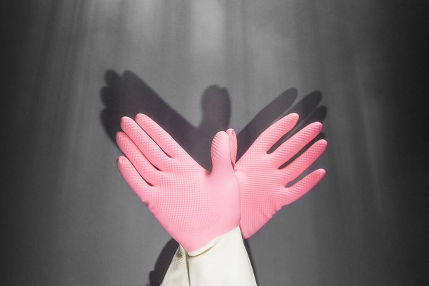 Teatro de sombras. Las manos en guantes de goma muestran la figura de una paloma. En la pared oscura, la sombra de las manos en forma de pájaro. - Foto, imagen
