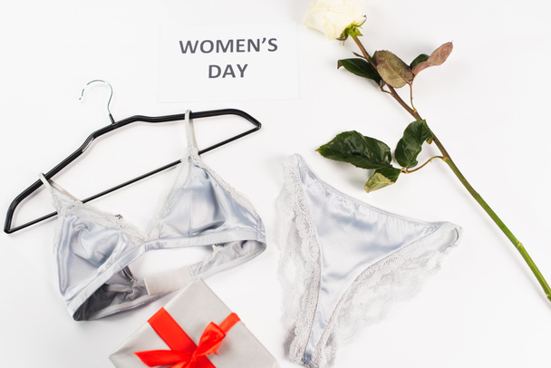 Top view of lingerie near card with womens day lettering, rose and gift on white background  - Fotoğraf, Görsel