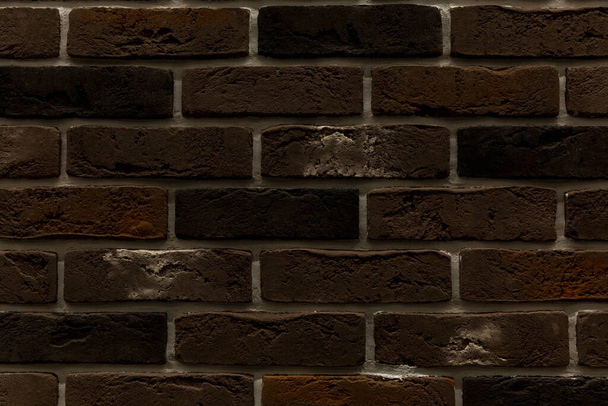 The surface of a dark brown brick wall. Decorative facing tiles. Background. Space for text. - Foto, afbeelding