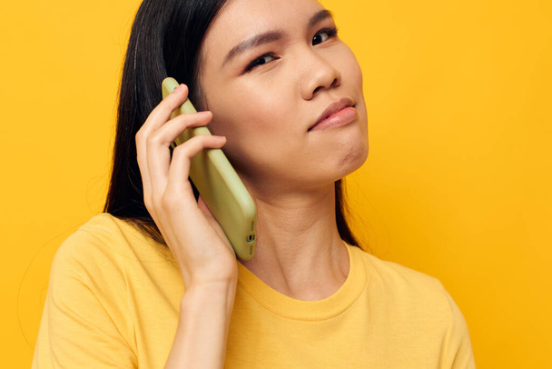 woman with Asian appearance phone communication fun use studio model unaltered - Zdjęcie, obraz