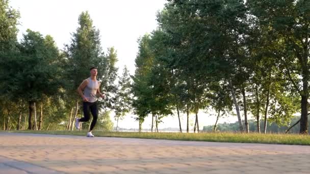 открытая тренировка спортсмена бегущего в парке, бегуна - Кадры, видео