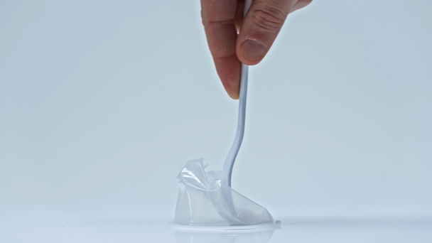 обрезанный вид человека нажатием пластиковой чашки с одноразовой вилкой на сером - Фото, изображение