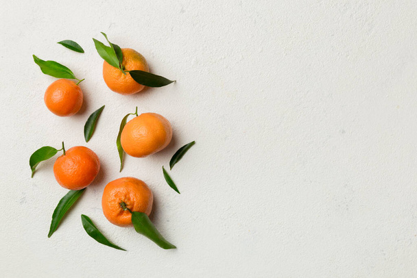 Many fresh ripe mandarin with green leaves on colored background, top view, space for text. - Fotó, kép
