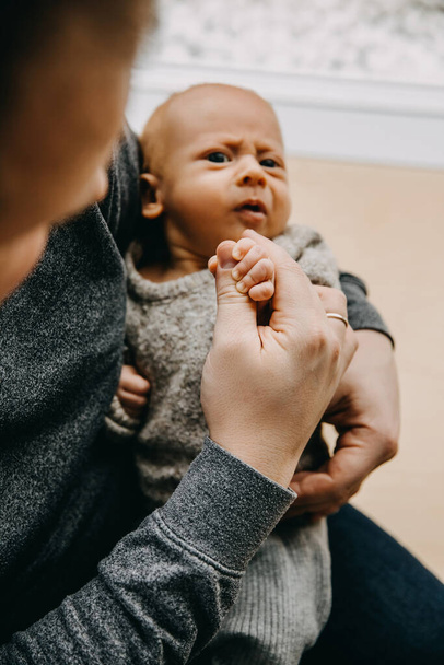Primer plano del padre sosteniendo a un bebé de un mes en brazos. - Foto, imagen