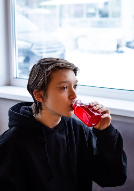 A teenager sits alone in a cafe - Фото, изображение