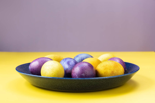 Ostereier auf einem Teller, auf gelbem Hintergrund. Konzept. Bemalte Eier. - Foto, Bild