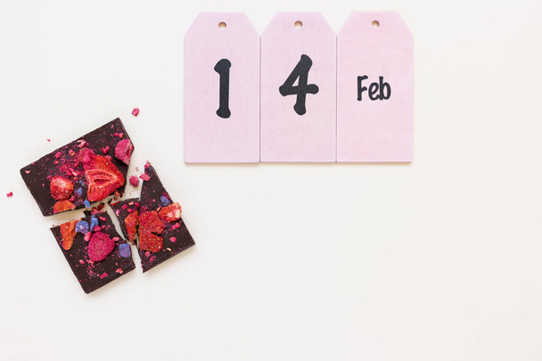 Handgemachte dunkle Schokolade mit getrockneten Früchten und Beeren und Text 14. Feb. Hintergrund zum romantischen Valentinstag - Foto, Bild