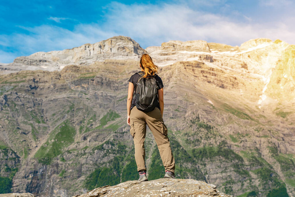 Mulher jovem com uma mochila no topo de uma rocha em uma bela paisagem selvagem. Discovery Travel Conceito de destino - Foto, Imagem