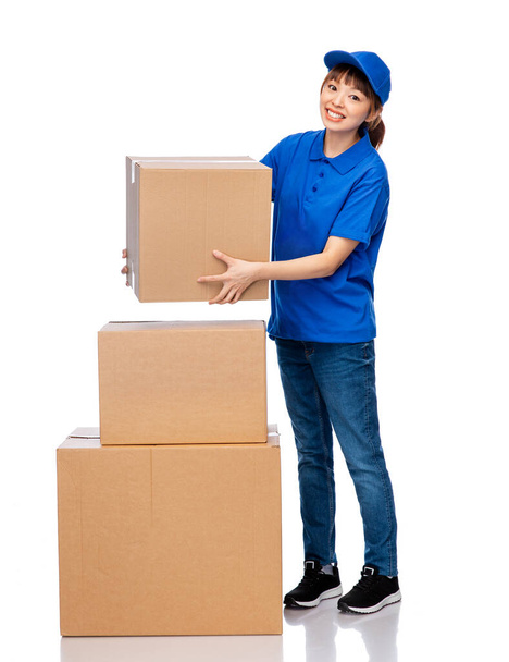 delivery woman in blue uniform with parcel boxes - Foto, imagen