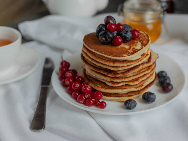 pancakes with forest berries red currant blueberries and tea  - Foto, Imagem