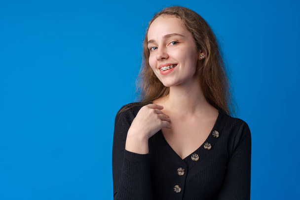 Pretty smiling girl portrait against blue background in studio - Foto, imagen