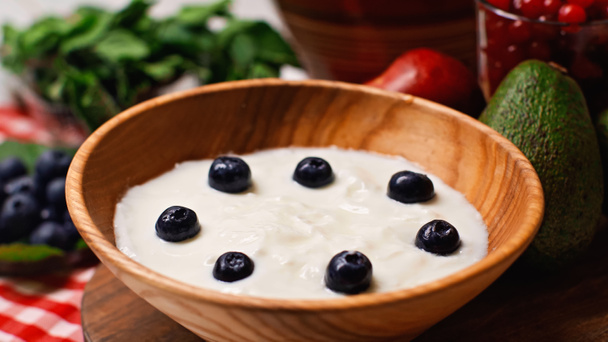 close up of fresh blueberries in wooden bowl with yogurt - Photo, Image