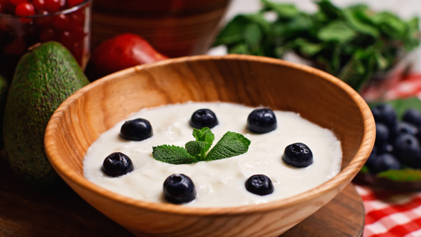 close up of fresh peppermint and blueberries in wooden bowl with yogurt  - Fotoğraf, Görsel