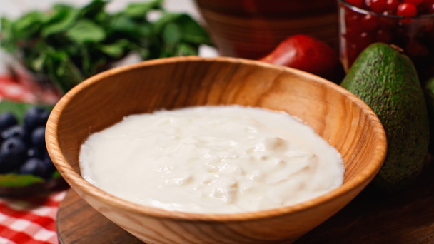 close up of fresh and sweet yogurt in wooden bowl  - Foto, imagen