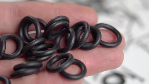 Rubber sealing o-rings in hand for industrial and home plumbing use. Round gaskets. Close up. Macro - Footage, Video