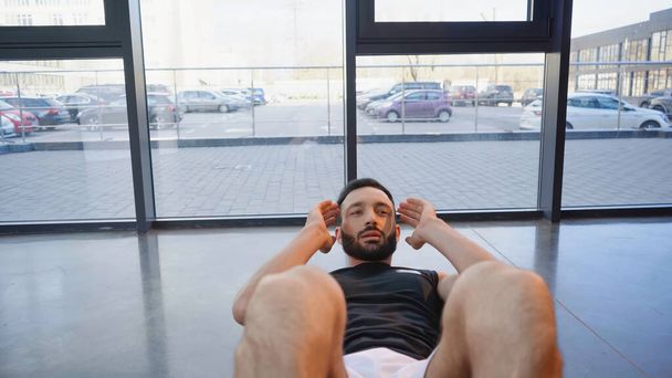 Бородатый спортсмен делает приседания в спортзале  - Фото, изображение