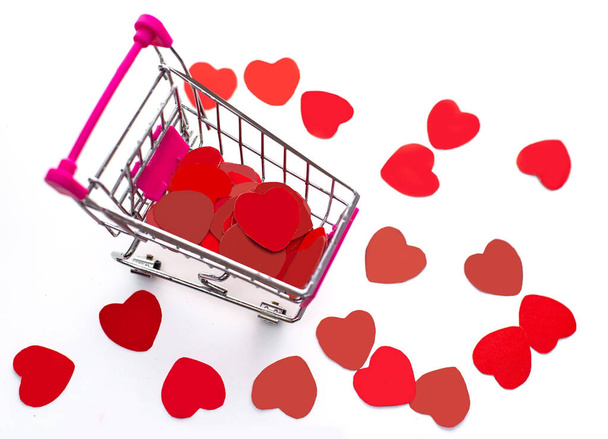 Vista dall'alto del carrello della spesa in metallo con molti cuori artigianali di carta rossa, vendita di San Valentino - Foto, immagini
