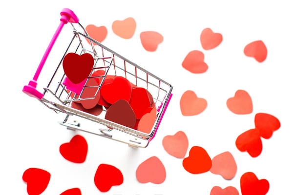 Corazones de papel rojo caídos en el carrito de la compra, comprar amor o me gusta las redes sociales, venta del día de San Valentín - Foto, Imagen