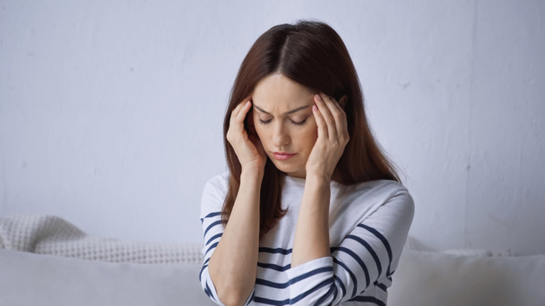 kimerült nő migrén megérinti fejét, miközben otthon ül - Fotó, kép