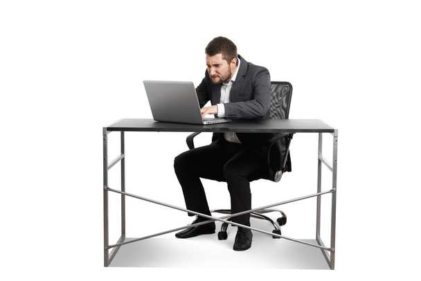 muž sedí u stolu a pomocí notebooku - Fotografie, Obrázek