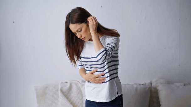 brunette femme toucher le ventre douloureux tout en souffrant de douleurs abdominales - Photo, image