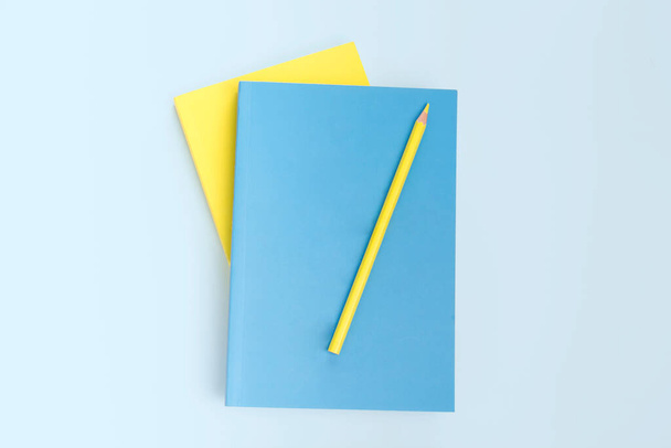 libro piatto e cancelleria a matita, colore giallo e blu - Foto, immagini