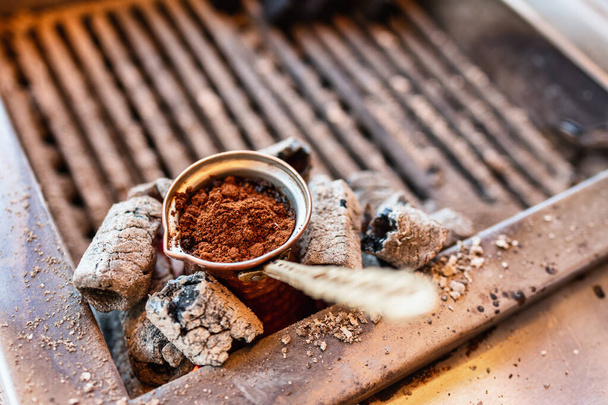 伝統的な方法で炭ストーブの上に真鍮製のセブでトルコ式コーヒーを醸造イスタンブール、トルコの通り - 写真・画像