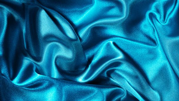 Jasnoniebieska satyna jedwabna. Składa się na błyszczącej powierzchni tkaniny. Piękne tło teal z miejsca do projektowania - Zdjęcie, obraz