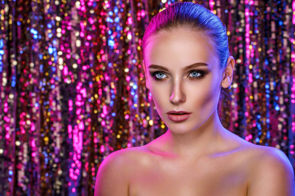 Beauty portrait of a High Fashion woman in colorful bright neon lights posing On colourful vivid sequin background - Photo, Image