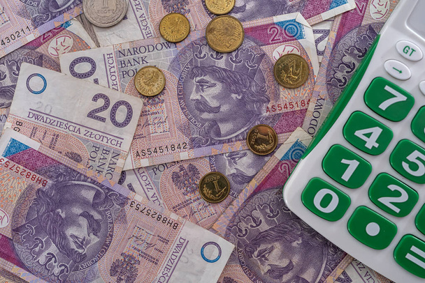 gyönyörű, új lengyel zloty bankjegyek gyönyörűen szétszórva az asztalon a számológép mellett. Pénzforgalmi számviteli üzleti számviteli koncepció - Fotó, kép