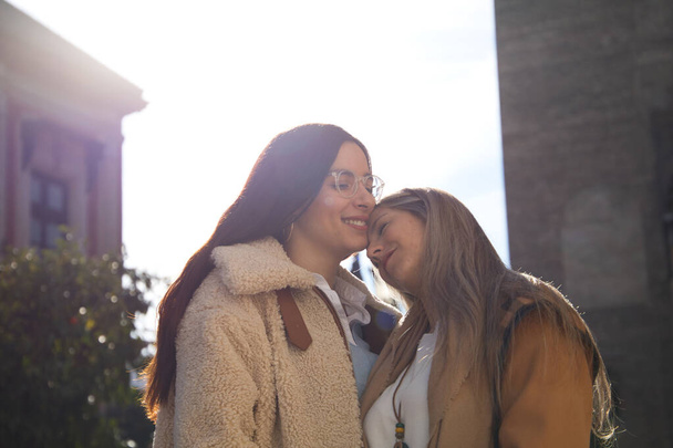 Newly married lesbian couple on a honeymoon in a city. The women are showing their love in public by walking around the city and kissing each other. Concept lgtb, equality and rights. - Photo, Image