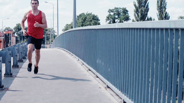 Nuori lenkkeilijä toppi ja shortsit käynnissä sillalla - Valokuva, kuva