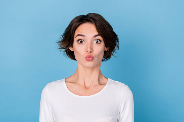 Photo of sweet pretty young lady dressed white shirt sending you kiss isolated blue color background - Foto, Imagen
