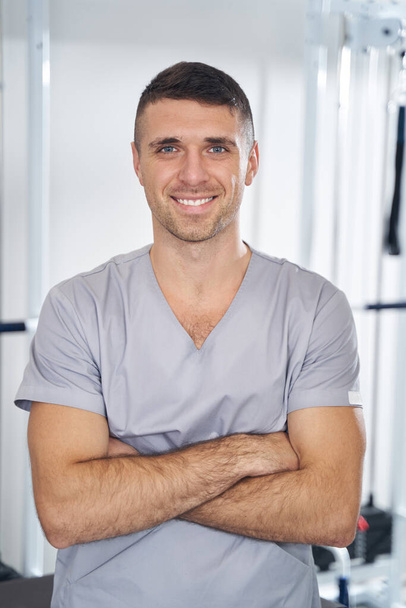 Cheerful doctor posing for photo with folded arms - Foto, afbeelding