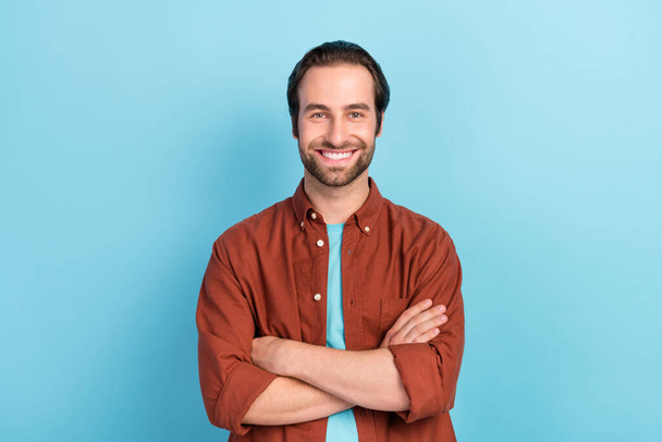 Photo of nice brown hairdo millennial guy crossed arms wear shirt isolated on blue color background - Фото, изображение