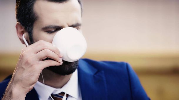 bearded businessman in earphone drinking coffee - Photo, image