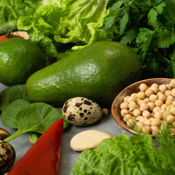 Friss, egészséges zöldségek avokádóval, csicseriborsóval, dióval és gyógynövényekkel az egészséges étrend érdekében. Rost- és zöldségfehérjéket tartalmazó kiegyensúlyozott étrend - Fotó, kép