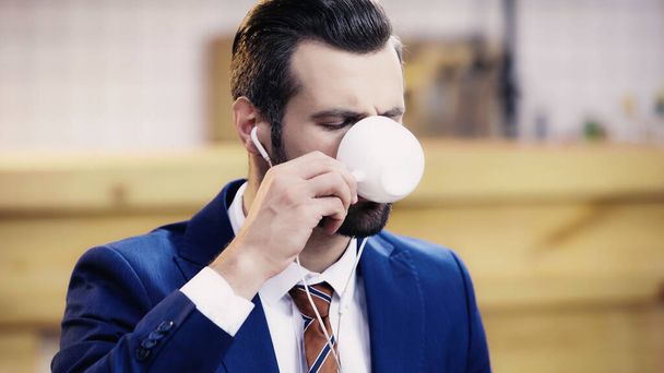 bearded businessman with earphone drinking coffee  - Photo, image