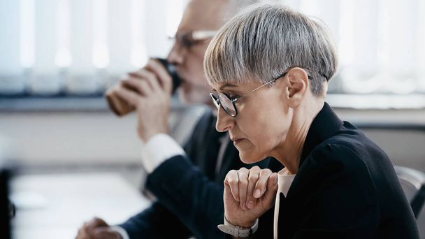 Side view of middle aged businesswoman in eyeglasses working in office  - Фото, изображение