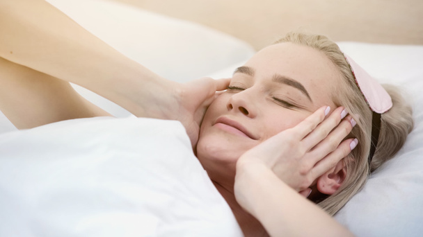 cheerful blonde woman with sleeping mask waking up in bed - Foto, immagini