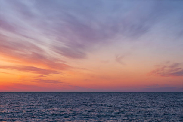 na obzoru na moři při západu slunce. na obloze jsou rozmazané krásné mraky. přímořská pláň bez lidí a bez předmětů - Fotografie, Obrázek