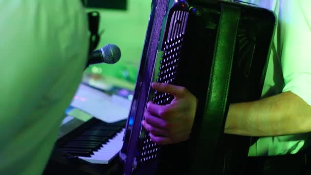 detailní záběr hudebníka hrajícího na akordeon do mikrofonu během hudebního vystoupení. Prsty mladého muže mačkají klávesy hudebního nástroje - Záběry, video
