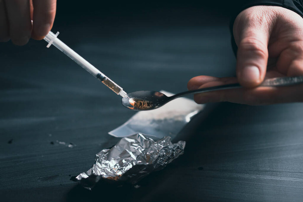Addict/junkie man preparing drugs. The concept of crime and drug addiction. - Zdjęcie, obraz