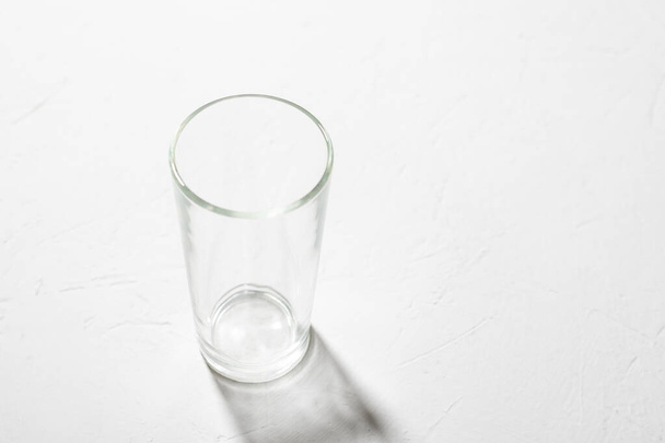 Empty glass beaker on a white background. Clear shadow, hard light. - Foto, afbeelding
