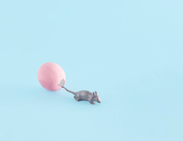 Рожева яєчна шкаралупа та іграшка для мишей, творче розташування на пастельному синьому фоні
.  - Фото, зображення