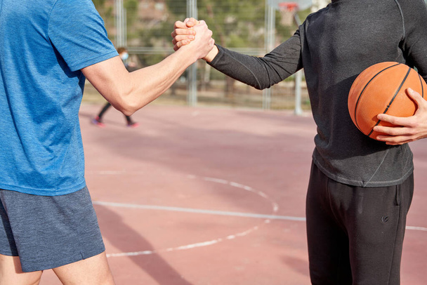 onherkenbare vrienden die elkaar high-fiven op het veld. begrip sport en vriendschap - Foto, afbeelding