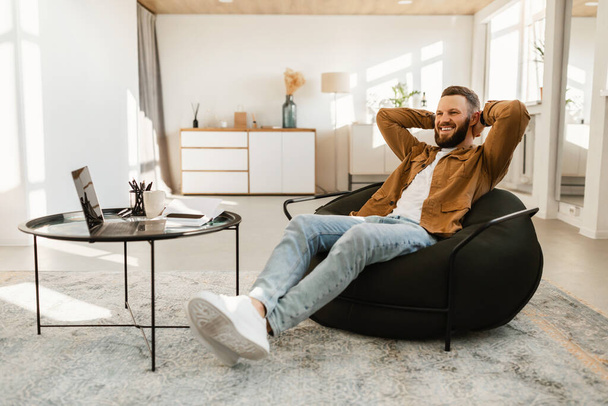 Happy Freelancer Guy sedí poblíž notebooku relaxační doma - Fotografie, Obrázek